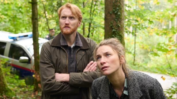Ein Ermittler-Duo betrachtet im Wald den Schauplatz eines Verbrechens