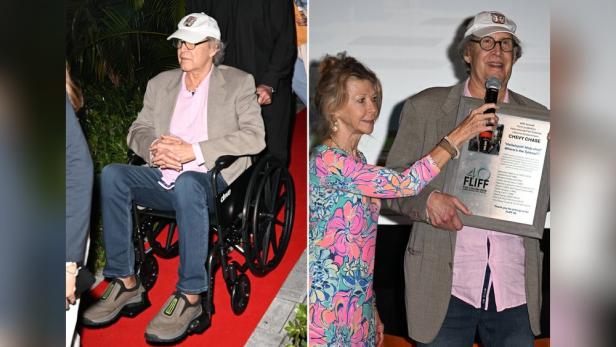 Jayni Chase im Rollstuhl und mit Ehefrau Jayni. Er hält einen Preis für sein Lebenswerk