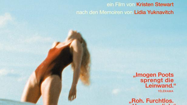 Frau im roten Badenanzug steht zurückgebeugt im Wasser