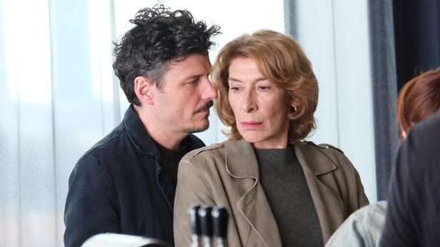 Manuel Rubey steht in Filmrolle als Callboy hinter Adele Neuhauser