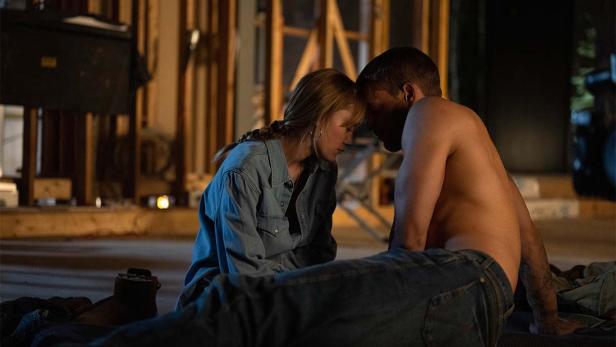 Mann und Frau sitzen aneinandergeschmiegt