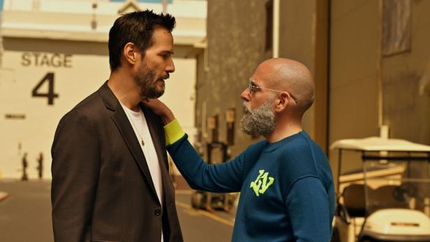 Jonah Hill legt Keanu Reeves vor einer Studiohalle die Hand auf die Schulter