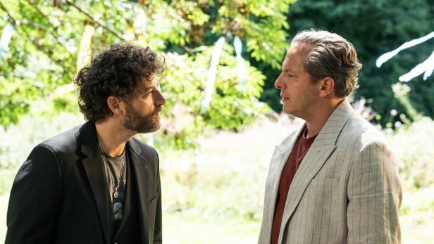 Timur Işık und Trystan Pütter stehen einander im Freien gegenüber