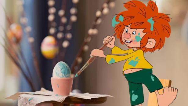 Pumuckl bemalt ein Osterei