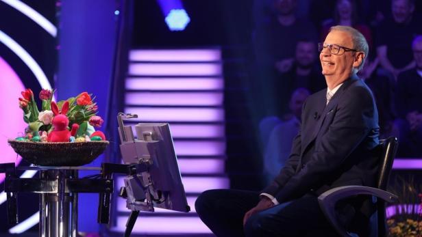 Breit lächelnder Günther Jauch sitzt im Studio vor einem großen Osterteller
