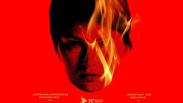 Frauenkopf auf Filmplakat, um den Flammen züngeln