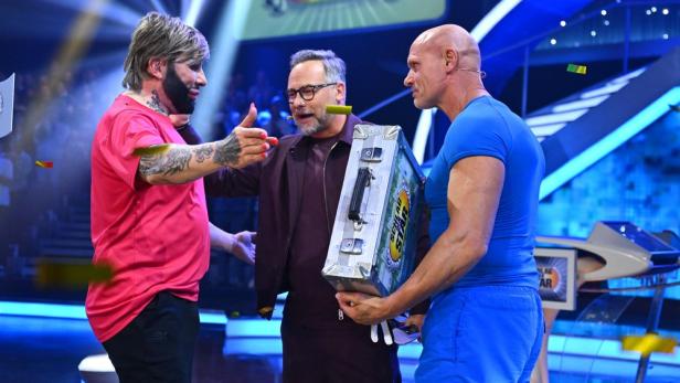 Harald Glööckler beglückwünscht den Geldkoffer haltenden Thorsten Legat