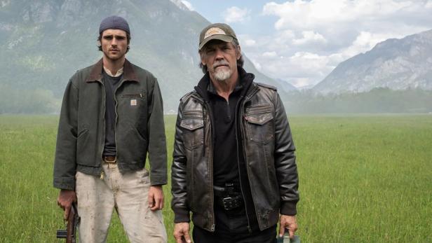 Jacob Elordi und Josh Brolin stehen auf großer Wiese mit Bergen im Hintergrund