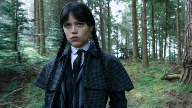 Jenna Ortega steht als Wednesday im Wald