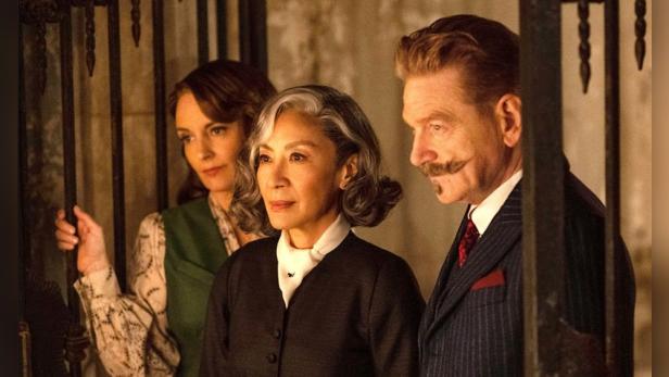 Kenneth Branagh als Hercule Poirot neben Tina Fey und Michelle Yeoh
