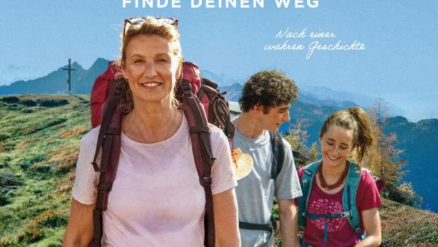 Drei Wanderer auf einem grasigen Höhenrücken