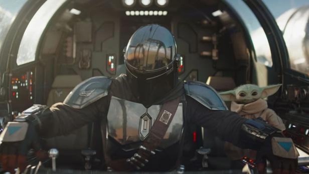 Der Mandalorianer sitzt mit Grogu im Cockpit eines Raumschiffs.