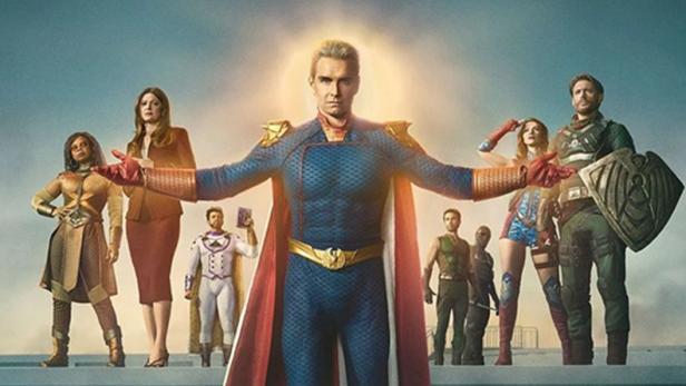 Eine Gruppe von Superhelden, darunter Homelander mit rotem Umhang, vor einem blauen Himmel.