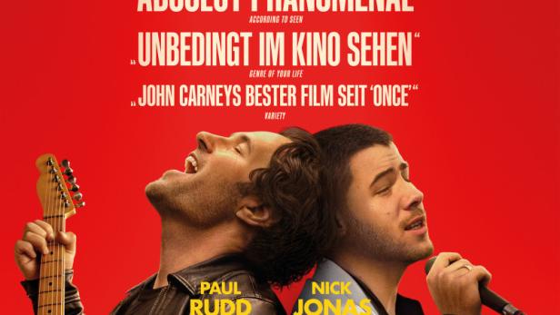 Auf rotem Grund: Paul Rudd mit Gitarre und Nick Jonas mit Mikrofon auf dem Filmplakat zu "Power Ballad".
