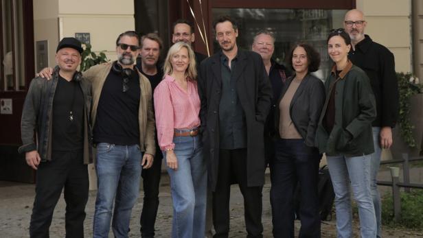 Eine Gruppe von zehn Personen posiert im Freien für ein Gruppenfoto.