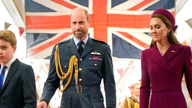 Prinz William in Uniform mit Kate und Prinz George vor der britischen Flagge.