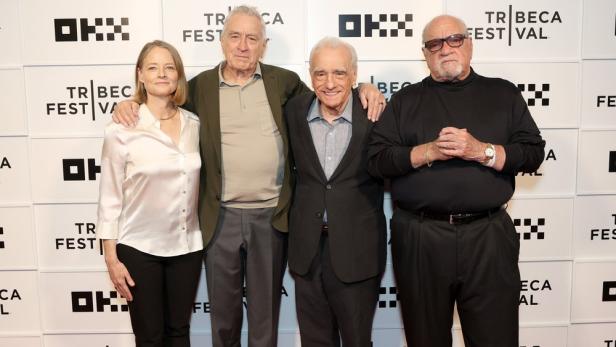 Jodie Foster, Robert De Niro, Martin Scorsese und ein weiterer Mann posieren vor einer Wand mit dem Logo des Tribeca Festivals.