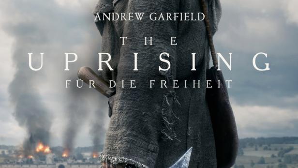 Andrew Garfield steht in mittelalterlicher Kleidung mit einer Sichel vor einer brennenden Festung auf dem Filmplakat zu „The Uprising“.