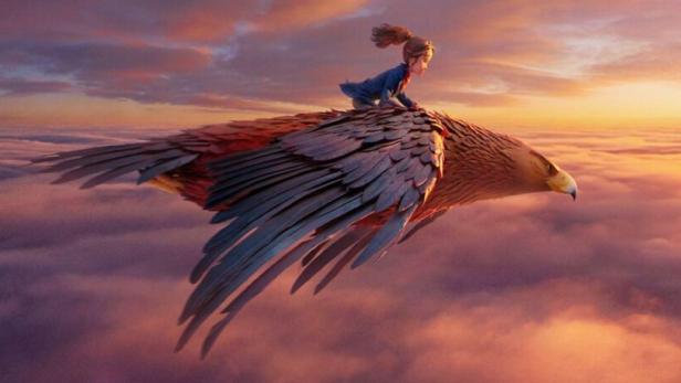 Ein Mädchen reitet auf einem riesigen Vogel über den Wolken bei Sonnenuntergang.