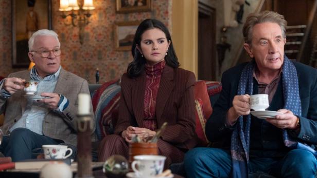 Steve Martin, Selena Gomez und Martin Short sitzen in einem gemütlich eingerichteten Raum und trinken gemeinsam Tee.