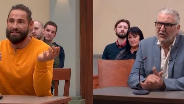 Zwei Männer sitzen nacheinander an einem Tisch vor einem Mikrofon, während im Hintergrund ein Publikum in einem Studio zuschaut.