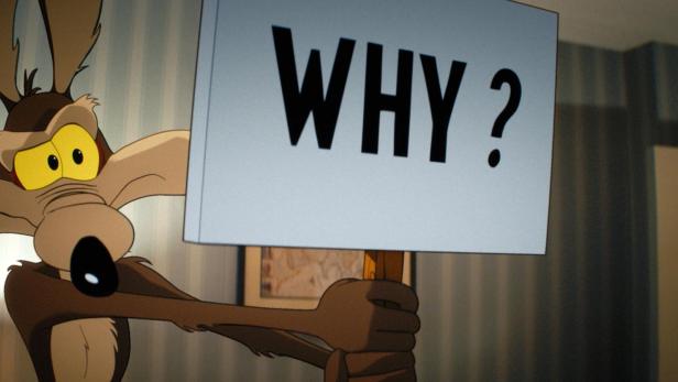 Wile E. Coyote hält ein Schild mit der Aufschrift „WHY ?“ in die Kamera.