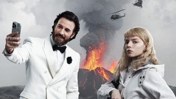 Filmposter zu „Sacrifice“ mit Chris Evans im weißen Smoking beim Selfie und Anya Taylor-Joy in weißer Kleidung vor einem ausbrechenden Vulkan.