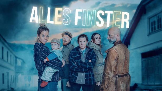 Sechs Personen und ein Baby stehen vor einem dörflichen Hintergrund, darüber steht der weiße Schriftzug „ALLES FINSTER“.