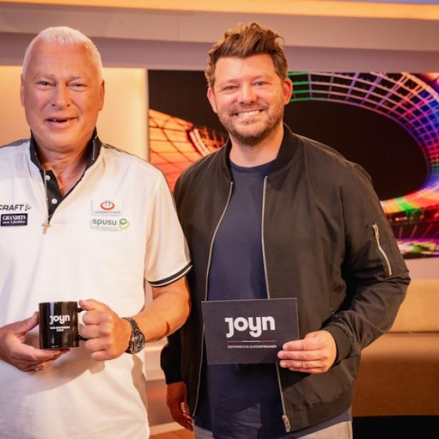 Toni Polster und ein weiterer Mann posieren mit „Joyn“-Branding im Studio.