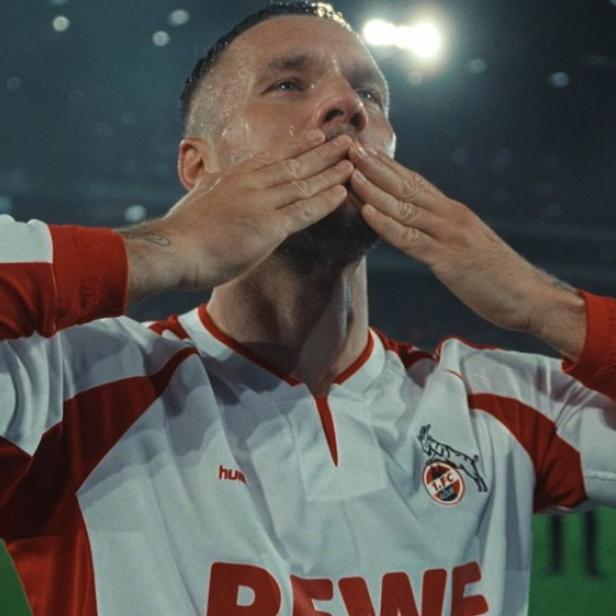 Lukas Podolski in einem Trikot des 1. FC Köln schickt Küsse in die Menge.