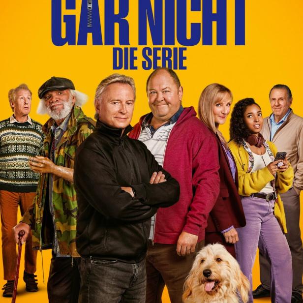 Das Filmplakat zur Serie „Ganz oder gar nicht“ zeigt eine Gruppe von Personen und einen Hund vor gelbem Hintergrund.