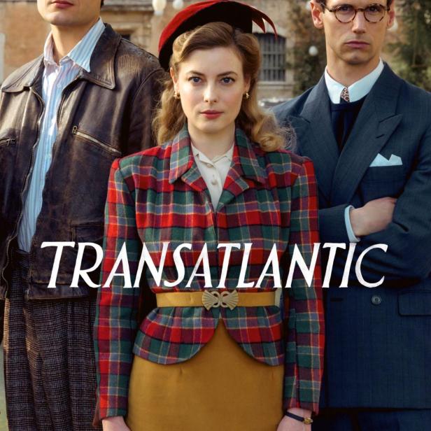 Drei Darsteller der Serie „Transatlantic“ stehen vor einem Gebäude.