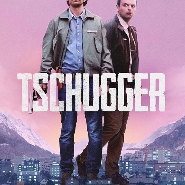 Das Filmplakat zu „Tschugger“ zeigt zwei Männer vor einer Stadtkulisse und Bergen.