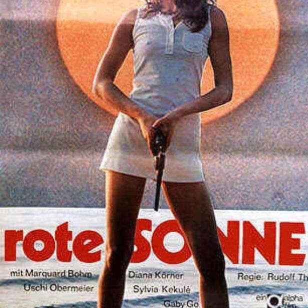 Das Filmplakat für „Rote Sonne“ zeigt eine Frau mit einer Pistole am Strand.