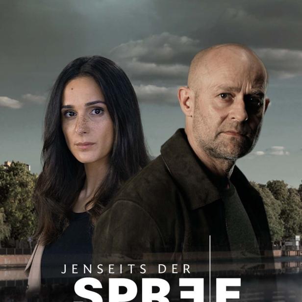 Das Filmplakat für „Jenseits der Spree“ zeigt zwei Ermittler vor einer Flusslandschaft.