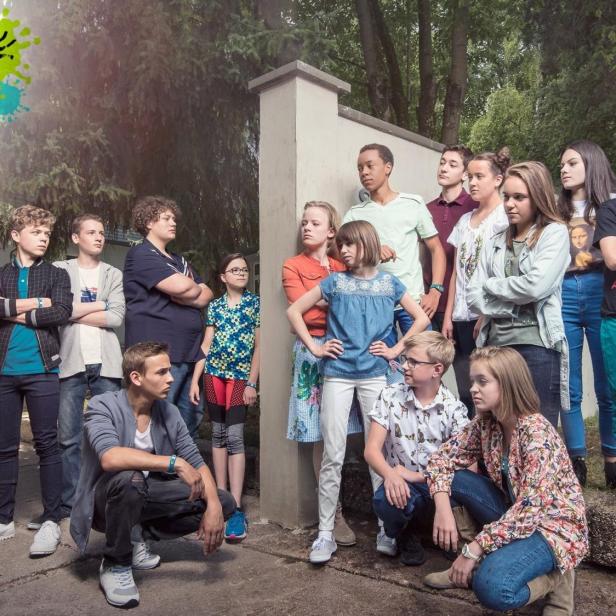 Eine Gruppe Jugendlicher steht vor dem Logo der Fernsehserie „Schloss Einstein“.