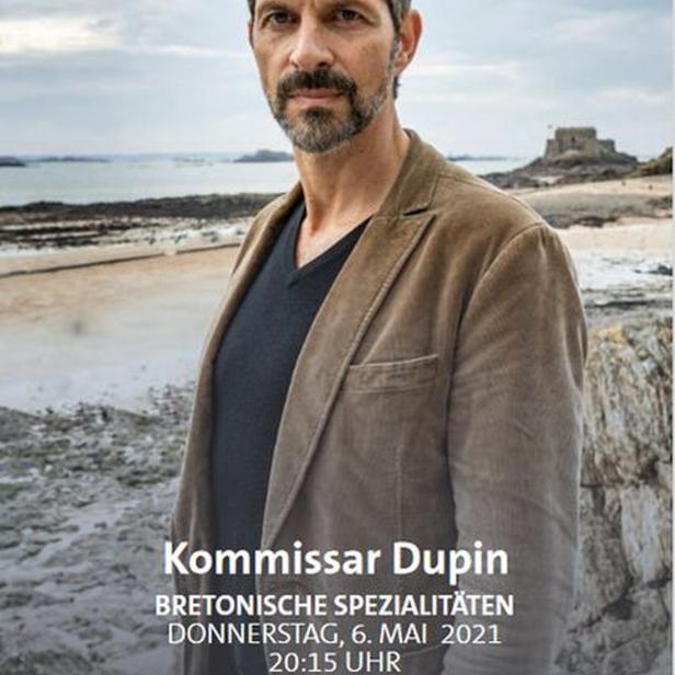 Kommissar Dupin vor einer Küstenlandschaft in der Bretagne.