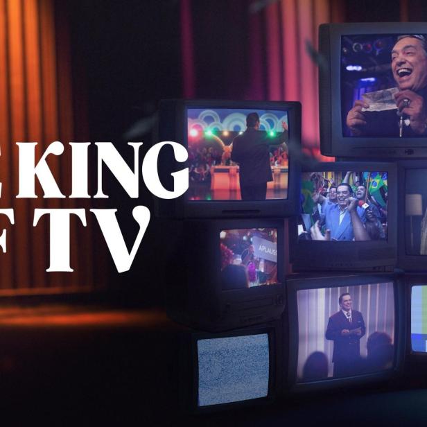 Der Schriftzug „The King of TV“ vor einem Stapel alter Fernsehgeräte, die verschiedene Szenen zeigen.