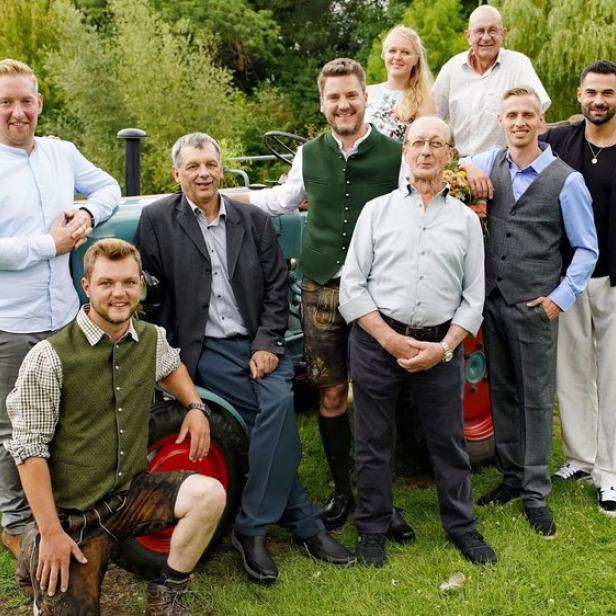 Gruppenbild von Bauern und Bäuerinnen vor Traktor