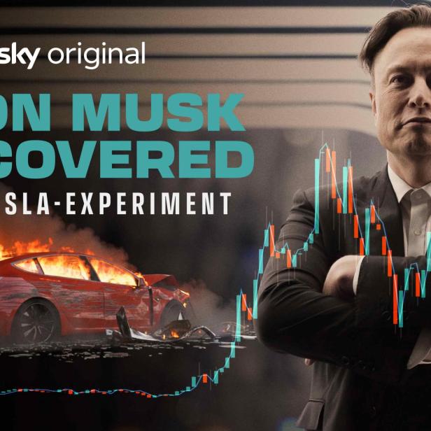 Elon Musk steht mit verschränkten Armen neben brennendem Auto