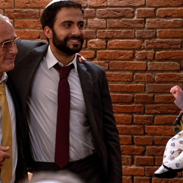 Zwei Männer stehen einer Frau mit Baby gegenüber