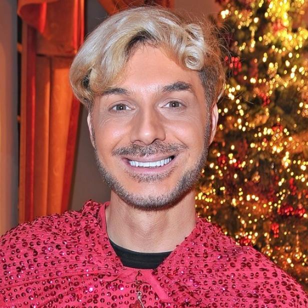 Sam Dylan vor geschmücktem Weihnachtsbaum