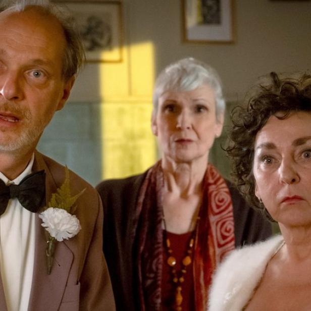 Zwei Frauen und ein Mann machen überraschte Gesichter