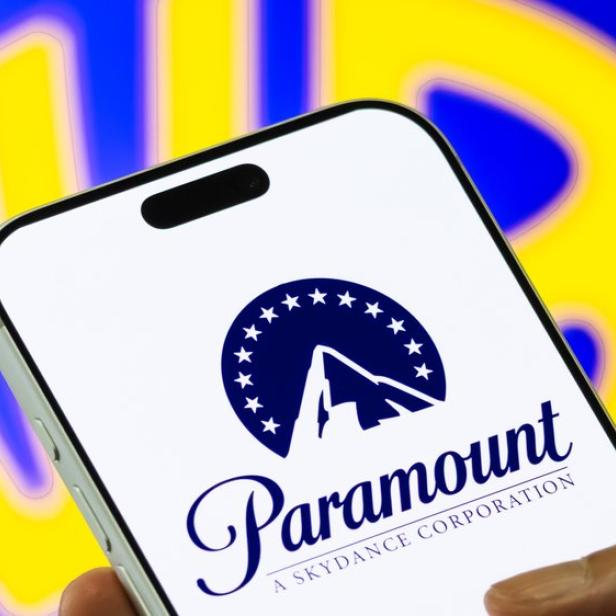 Paramount Skydance Logo auf Handy - im Hintergrund das Warner Bros Logo