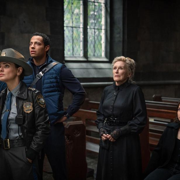 Eine Gruppe von Gemeindemitgliedern steht vor den Kirchenbänken