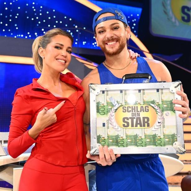 Sylvie Meis steht neben Riccardo Simonetti, der einen Geldkoffer hält