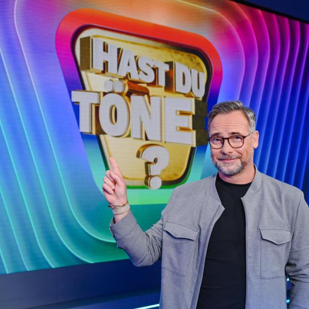 Matthias Opdenhövel zeigt im Studio auf den Schriftzug der Sendung "Hast du Töne?"
