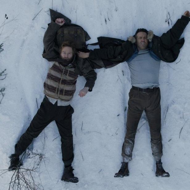 Kenneth Branagh und Ryan Reynolds liegen auf dem Rücken im Schnee