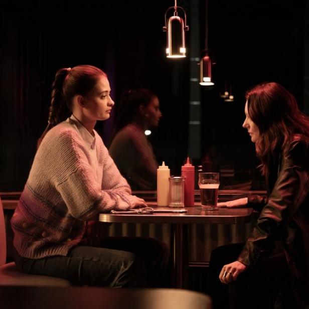 Philine Schmölzer und Lavinia Wilson sitzen einander in ihren Krimirollen nachts in einem Diner gegenüber