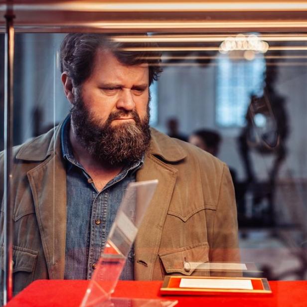 Antoine Monot betrachtet in der Serienrolle eine Vitrine im Museum